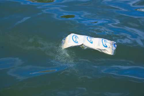 Waste Sludge Reducer bag floating on pond